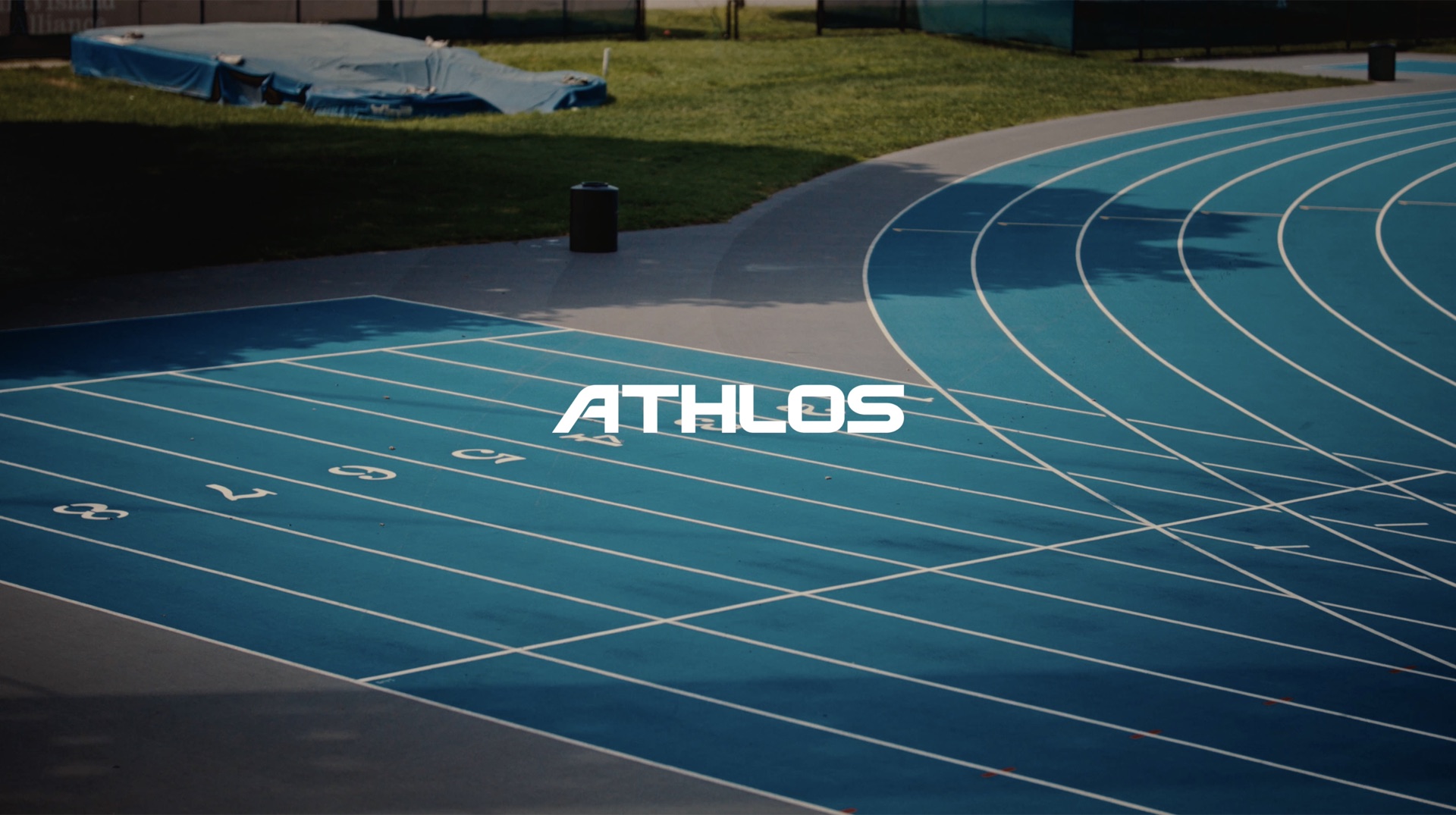 Three young athletes in blue tracksuits sitting together in empty stadium seating