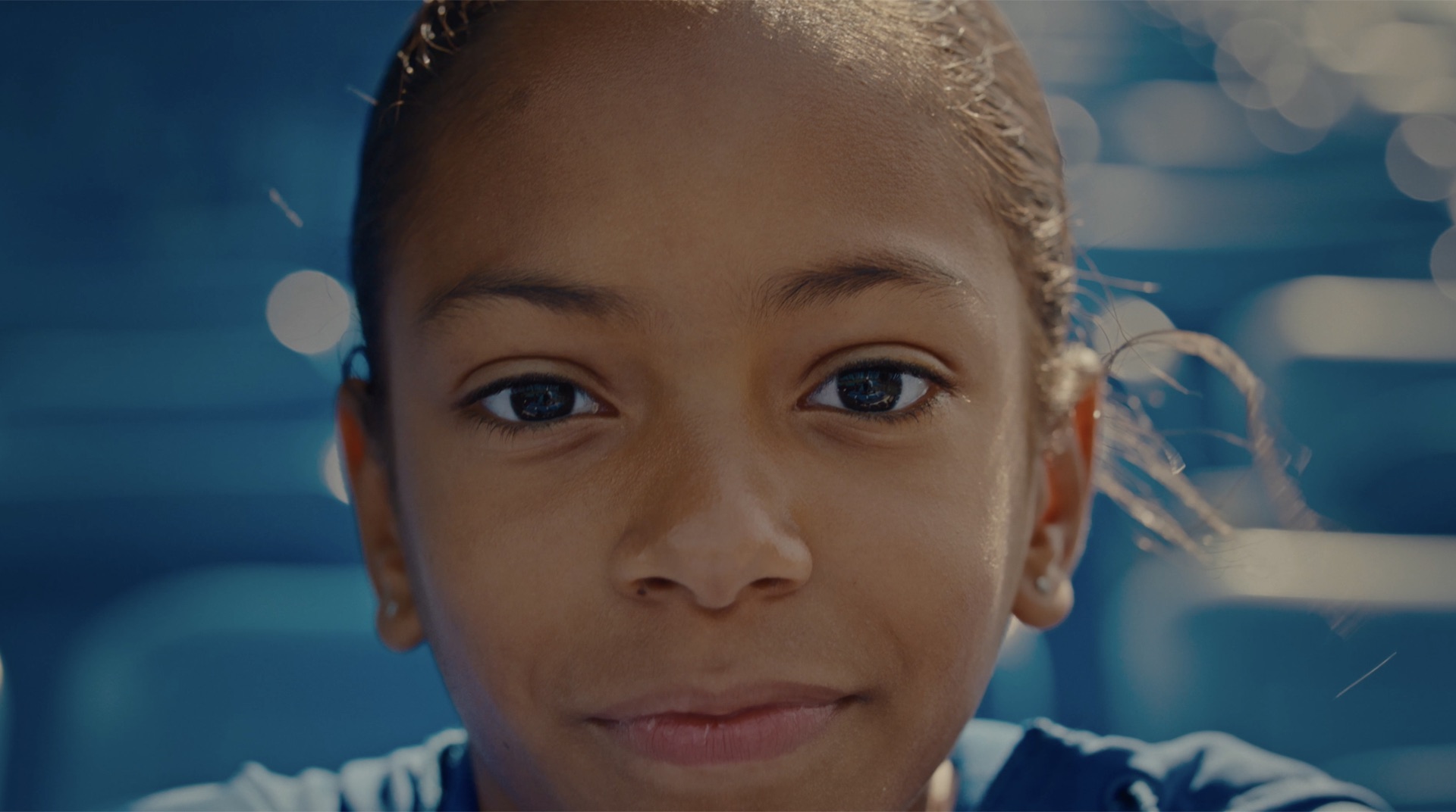 Close-up portrait of a young athlete with braided hair and hoop earrings