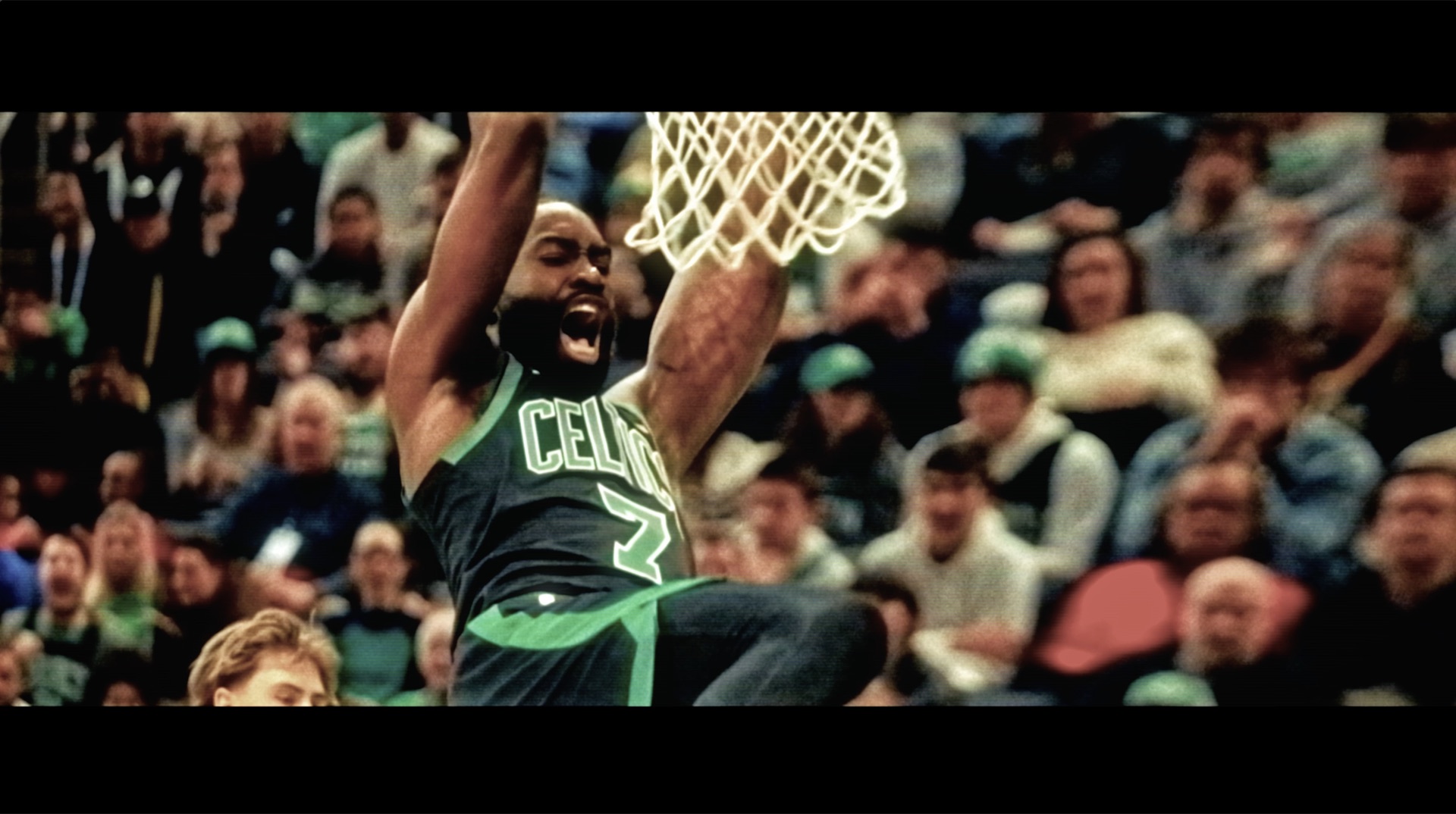 Celtics player celebrating a dunk, arena crowd behind him