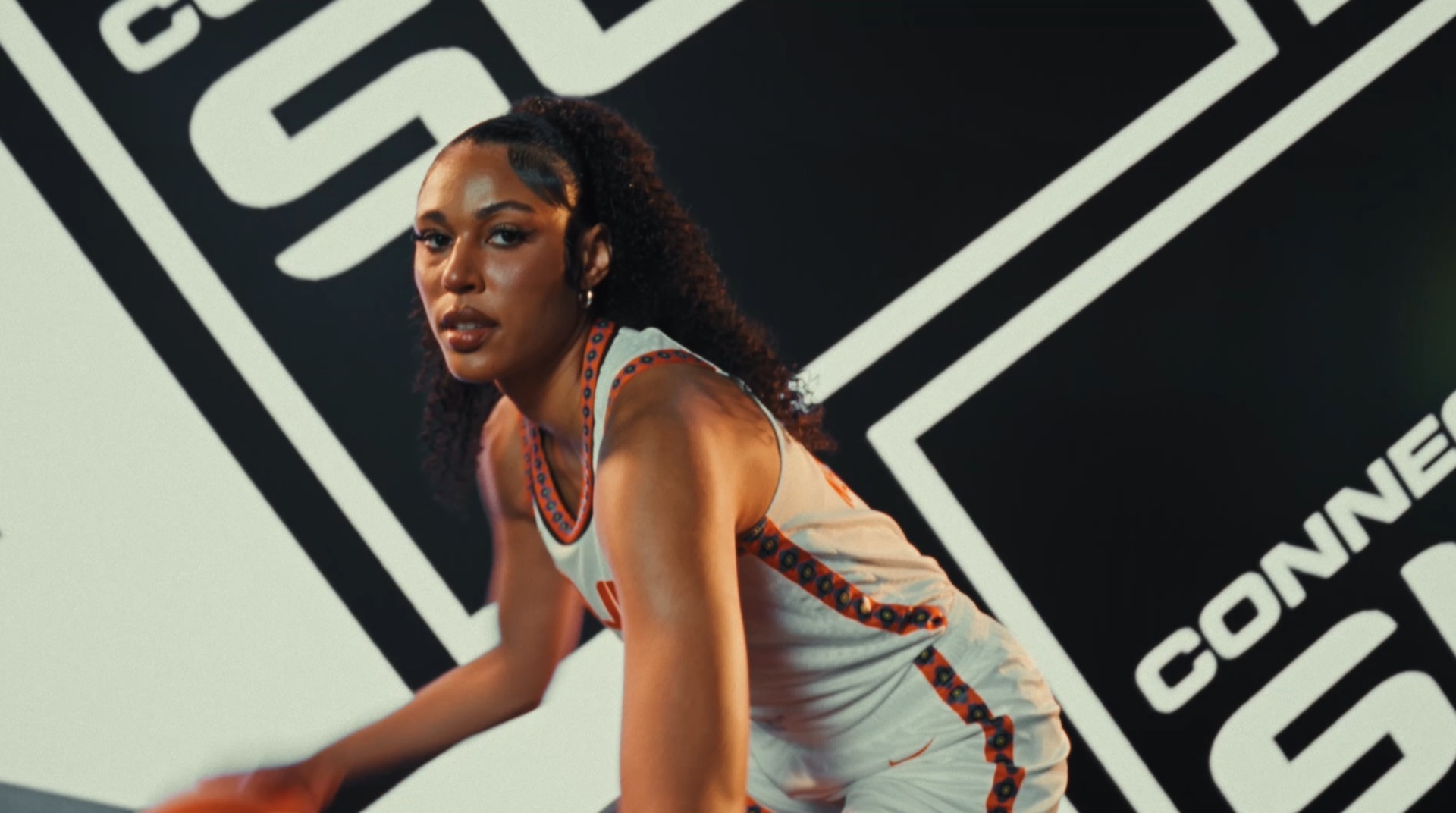 Player silhouetted with six arms holding basketballs, backlit by a glowing sun
