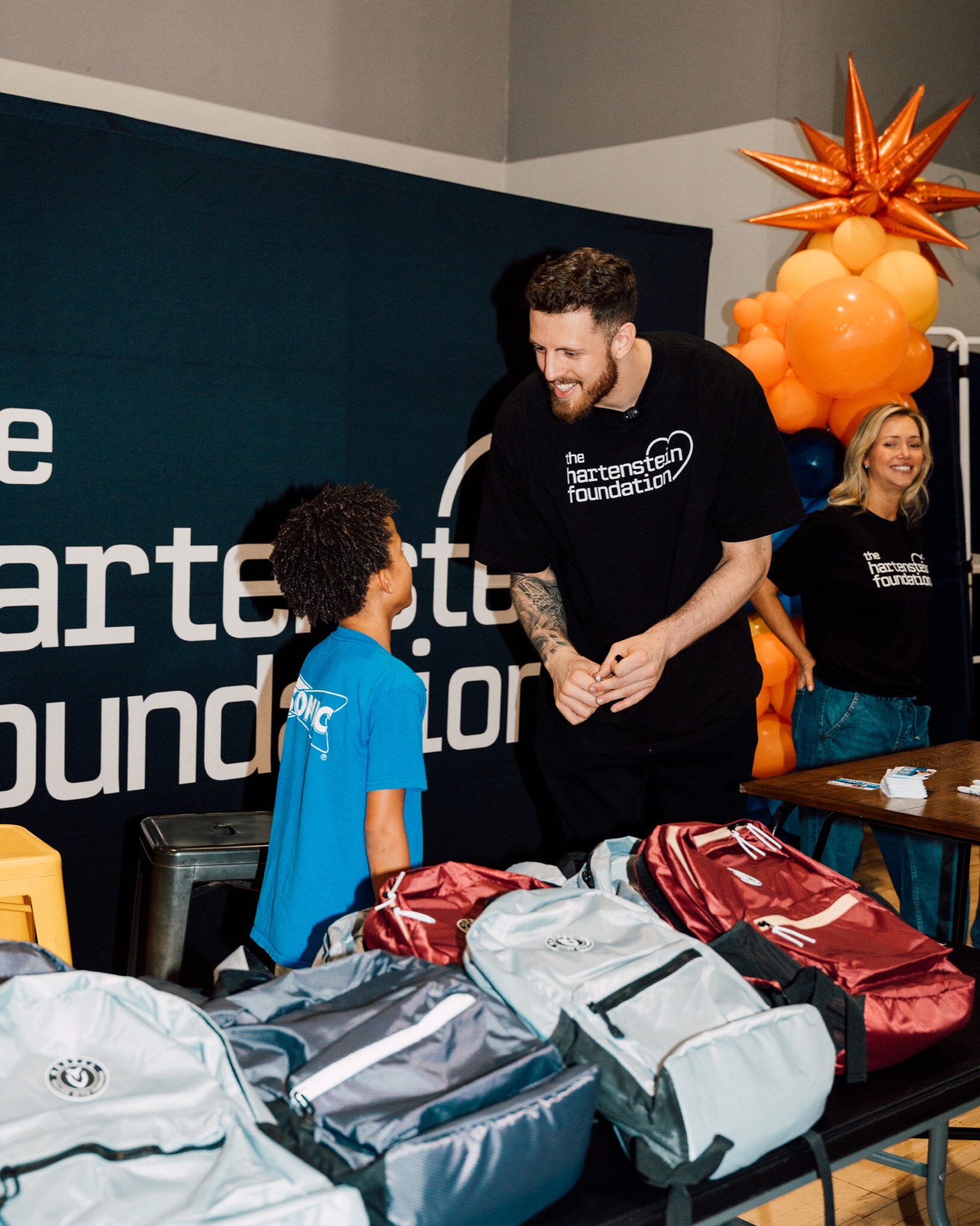 Isaiah Hartenstein smiling with a young fan at a Hartenstein Foundation backpack giveaway