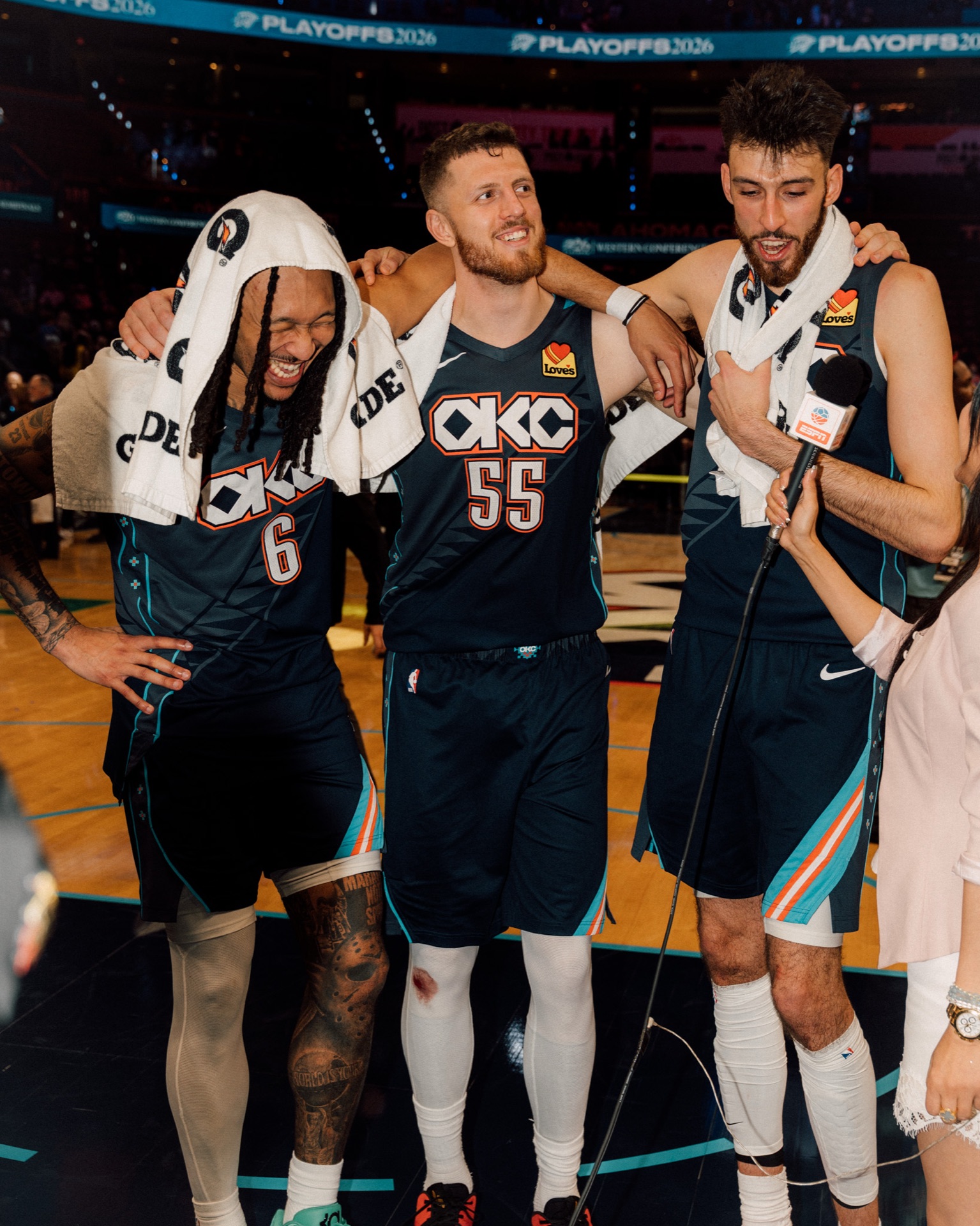 Isaiah Hartenstein with teammates after a playoff win, towels draped over their shoulders
