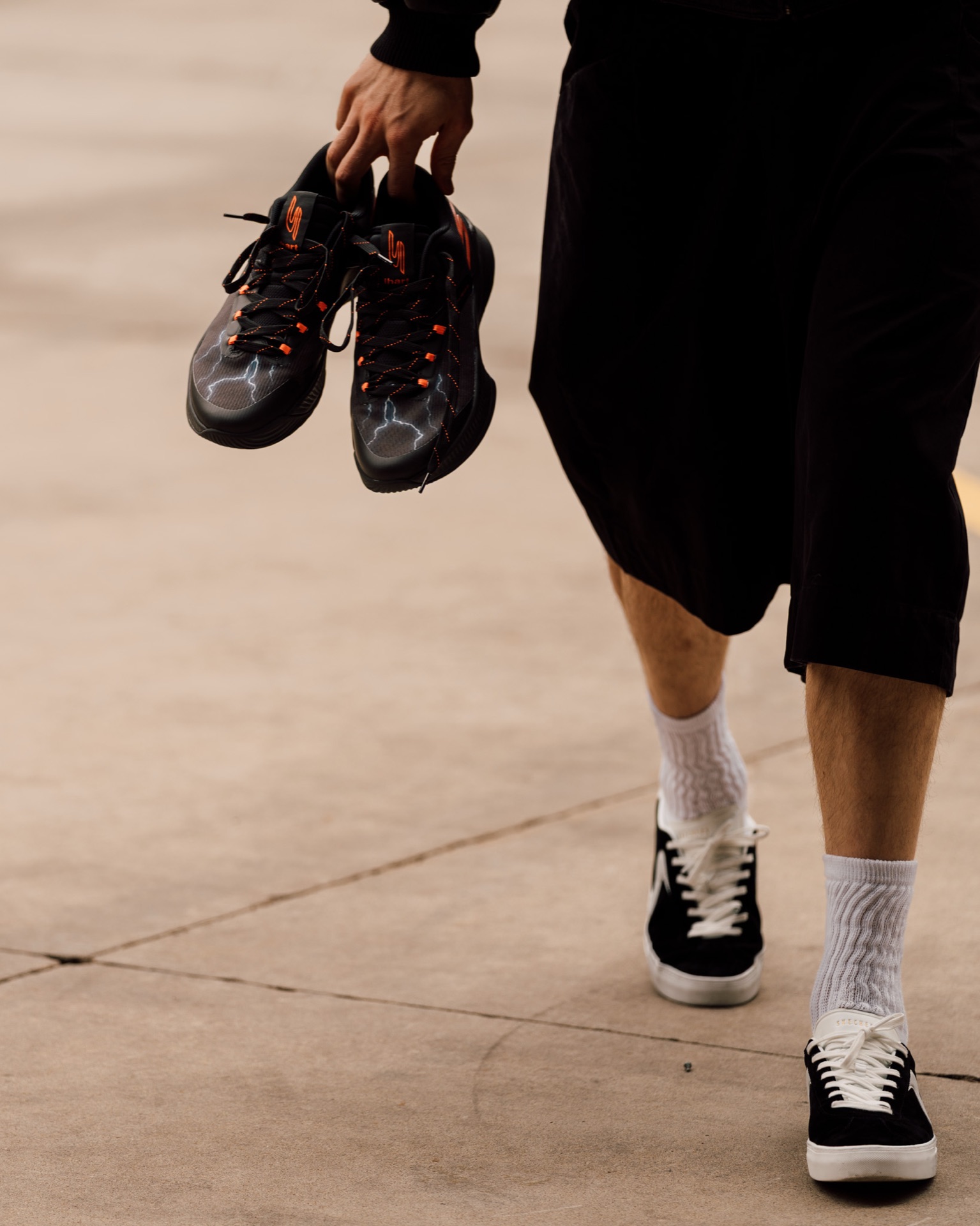 Close-up of Isaiah Hartenstein carrying his signature sneakers while walking