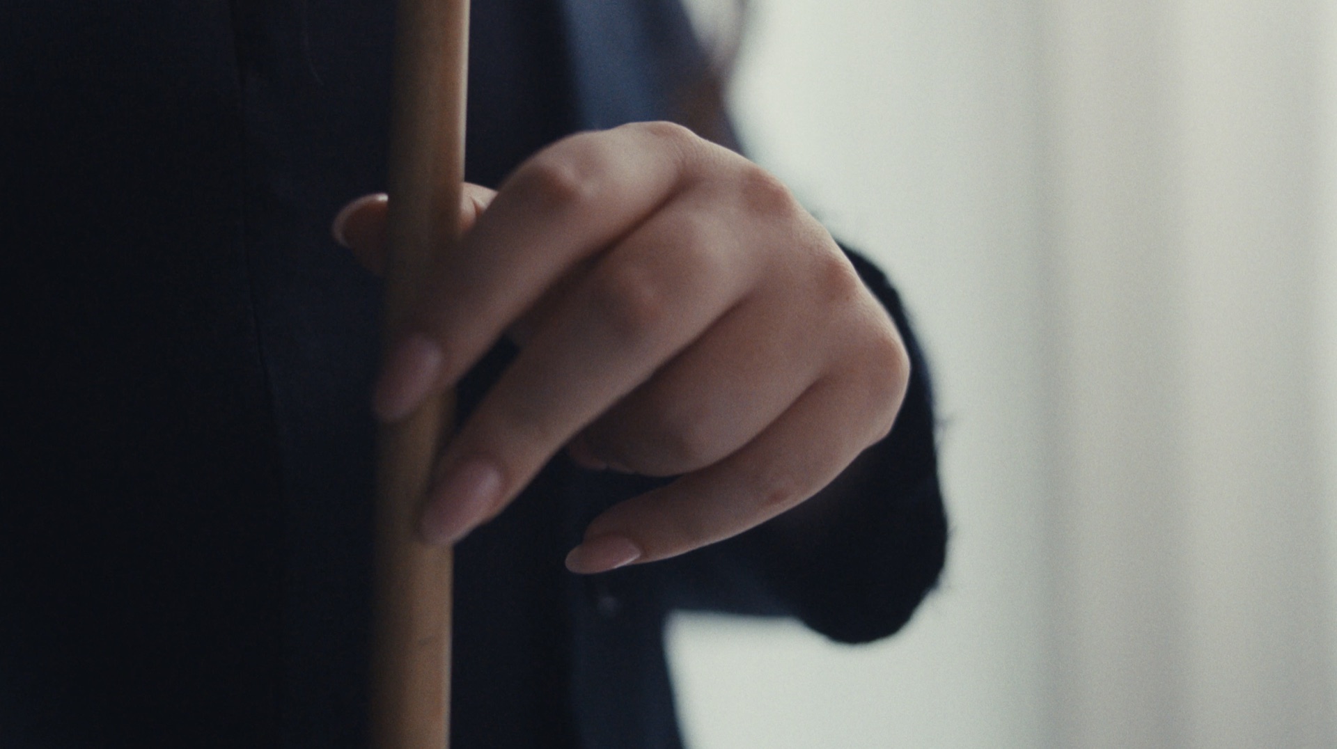 Close-up of a hand gripping a pool cue