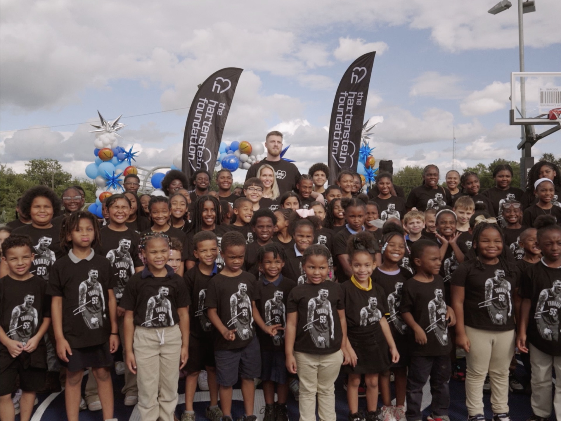 Group photo with local kids at the new community basketball court